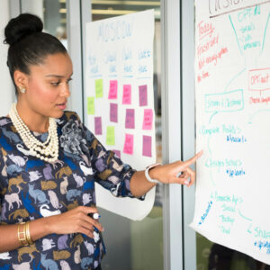 professional woman point to board during strategy session