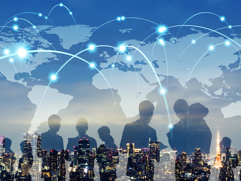 business people overlaid on a city skyline at night with connected globe in the background